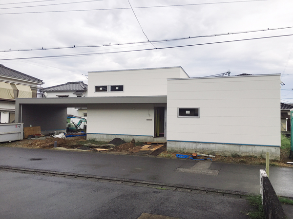 新宮佐野の平屋：足場が外れ、白い外壁と横に長く伸びる大きな庇が見える外観