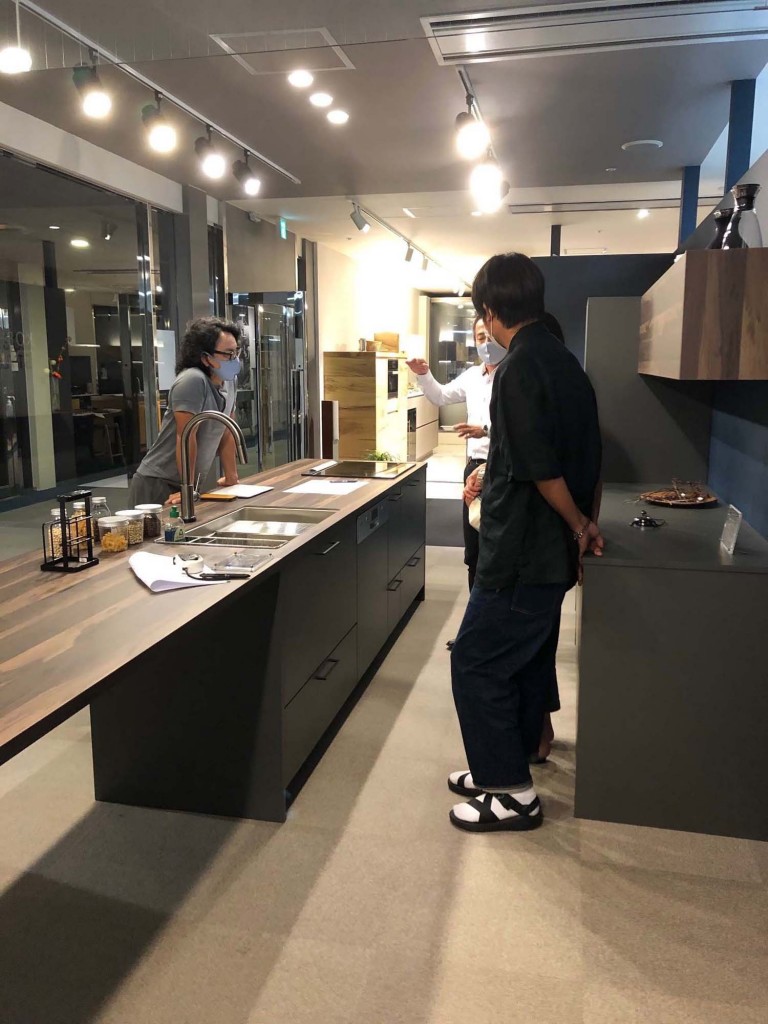 宝塚のライトコートハウス：ショールームで展示キッチンを囲んで打ち合わせる様子