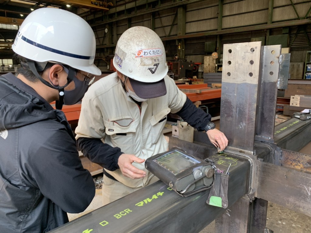 今里のガレージオフィス：測定器を使って鉄骨の溶接部を検査する様子