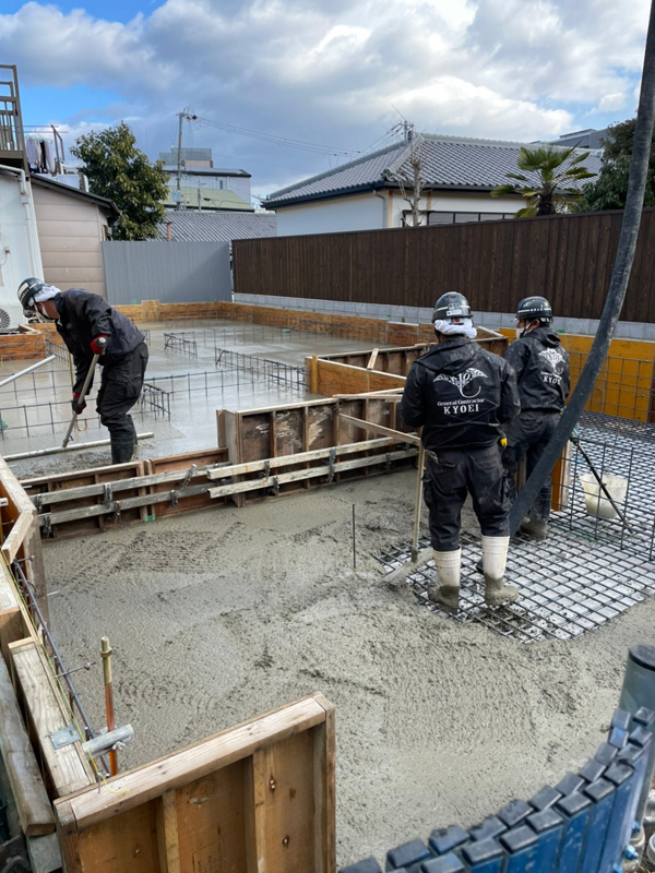 海老江の家：基礎に流し込んだコンクリートを締め固め、表面をならす職人たち
