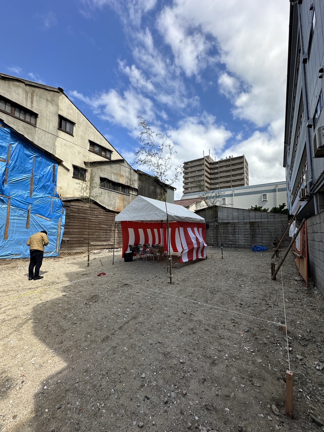 住之江のテナントビル。周囲を建物に囲まれた敷地に、紅白幕のテントを設けた地鎮祭の会場